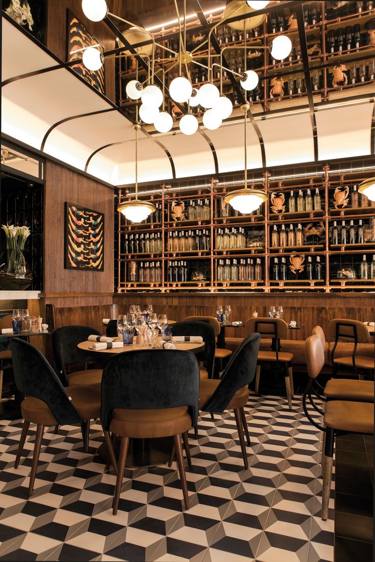 a restaurant with black and white checkered flooring, chandeliers hanging from the ceiling