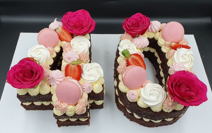 the number 50 is made out of chocolate cake and decorated with pink, white and red flowers