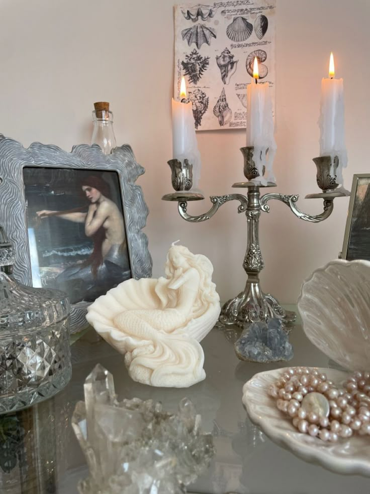 a table topped with candles and seashells on top of it