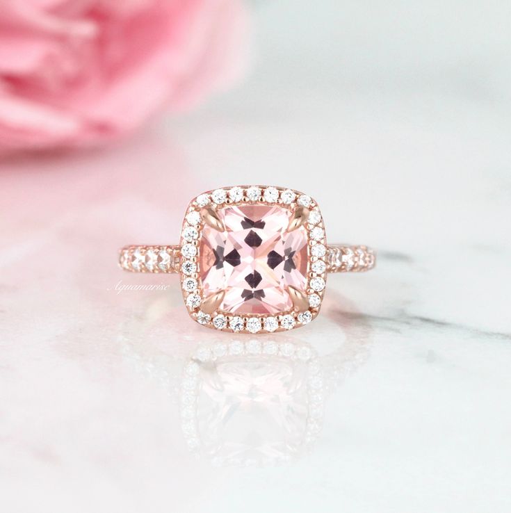 Beautiful Cushion Halo Morganite Ring ►Base metal: sterling silver (925) ►Plating: 14K Rose Gold ►Accented With Simulated Diamonds (CZ) Center Stone: Morganite Color: Peachy-Pink Shape: Cushion Measurements: 8.0 x 8.0 mm Carat Weight: 2.4 ct. (approx.) Gemstone creation: Lab-Created ►Please be aware that plated jewelry can wear off over time, if this is a concern we would suggest going with the sterling silver or solid gold jewelry option. ►Sterling silver ring version can be purchased here: htt Rose Gold Cushion Cut Morganite Ring, Classic Pink Halo Ring, Heirloom Pink Ring With Center Stone, Pink Morganite Halo Jewelry, Classic Morganite Diamond Ring For Wedding, Classic Morganite Diamond Wedding Ring, Classic Pink Diamond Ring With Center Stone, Classic Pink Halo Ring With Gemstone, Pink Halo Diamond Promise Ring