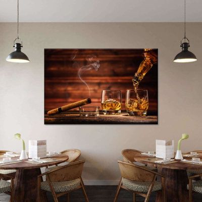 a table with two chairs and a painting on the wall above it that has an image of a bottle of whiskey being poured into glasses