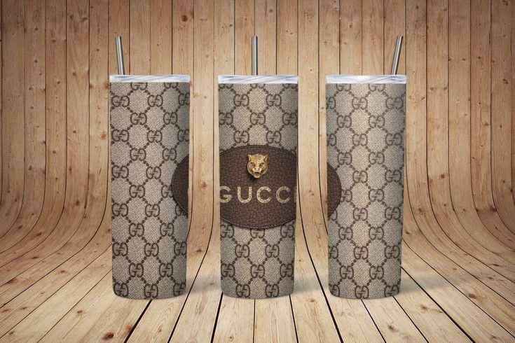 two gucci coffee cups sitting on top of a wooden floor