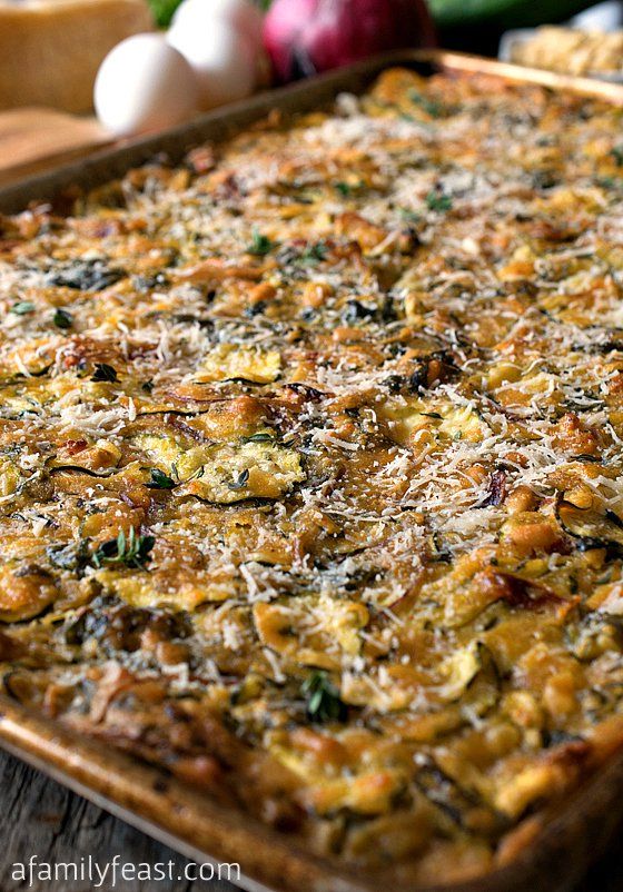 a casserole dish with spinach, cheese and other vegetables in the background