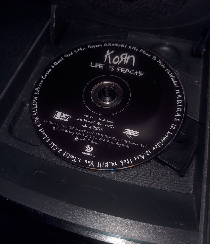 a cd that is sitting on top of a black box with writing on the disc