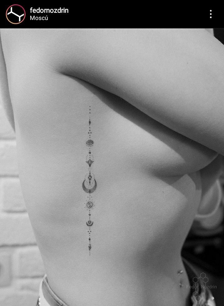 the back of a woman's stomach with an arrow and moon tattoo on it