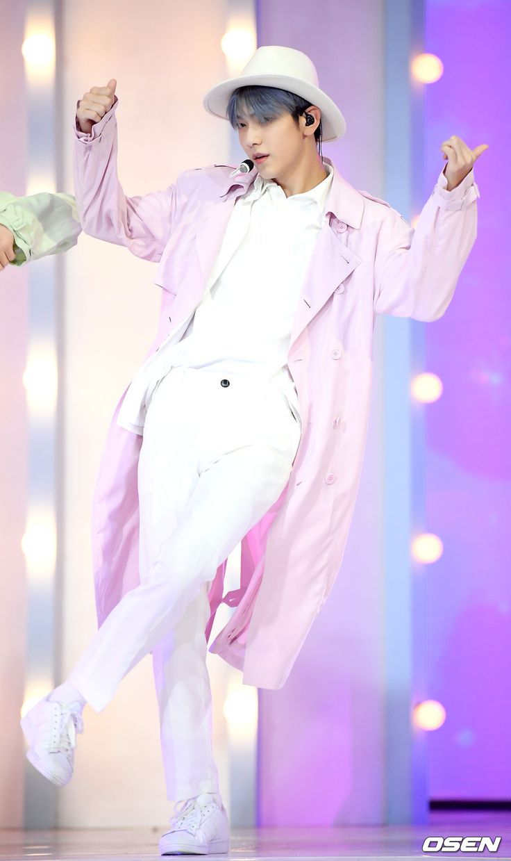 a male in a white suit and hat is dancing