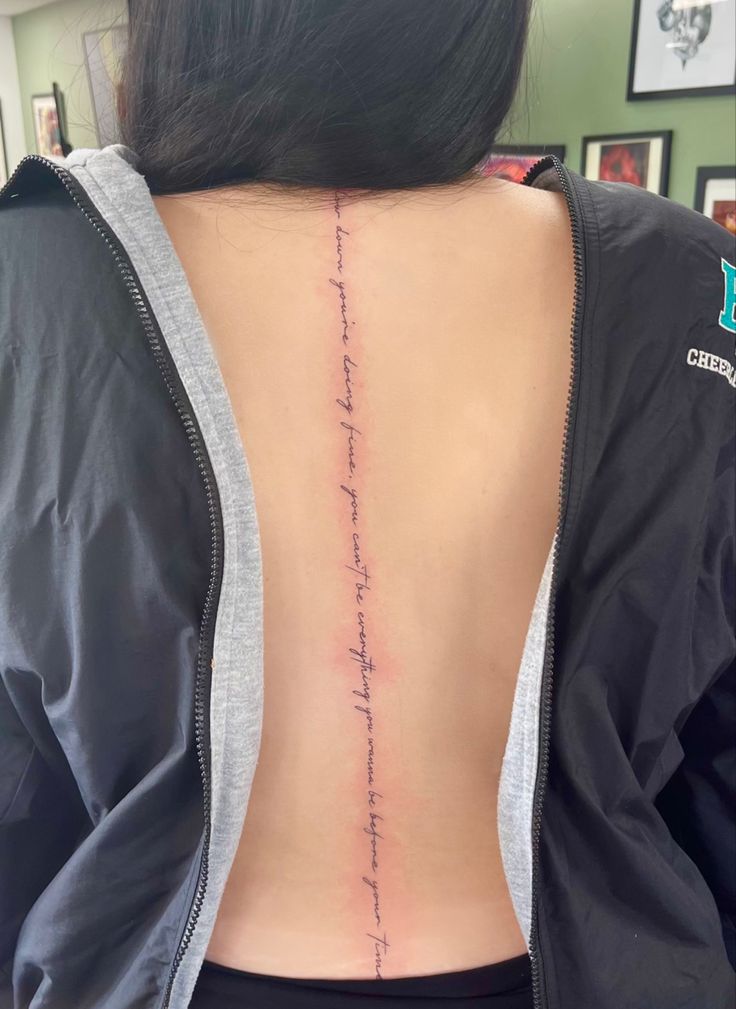 the back of a woman's neck with her handwriting written on it, in pink ink