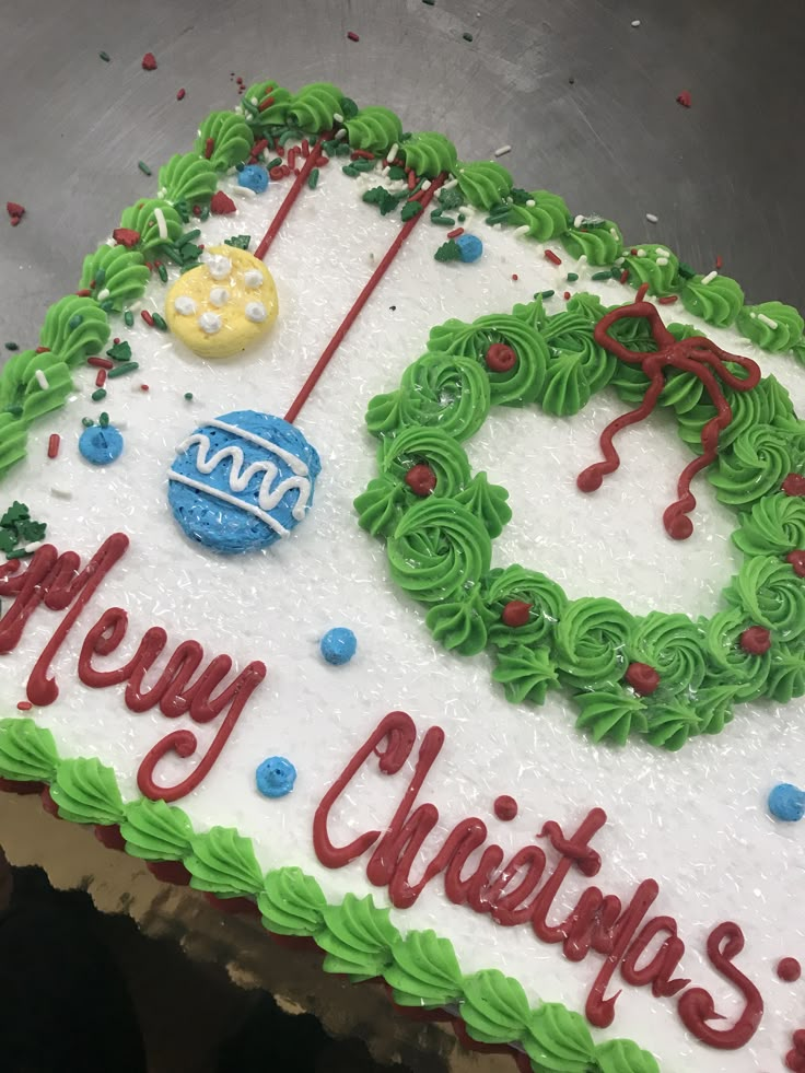 a cake decorated with green frosting and red writing that says happy christmas on it