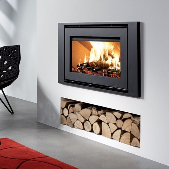 a fire place with logs in it and a wall mounted heater on the side