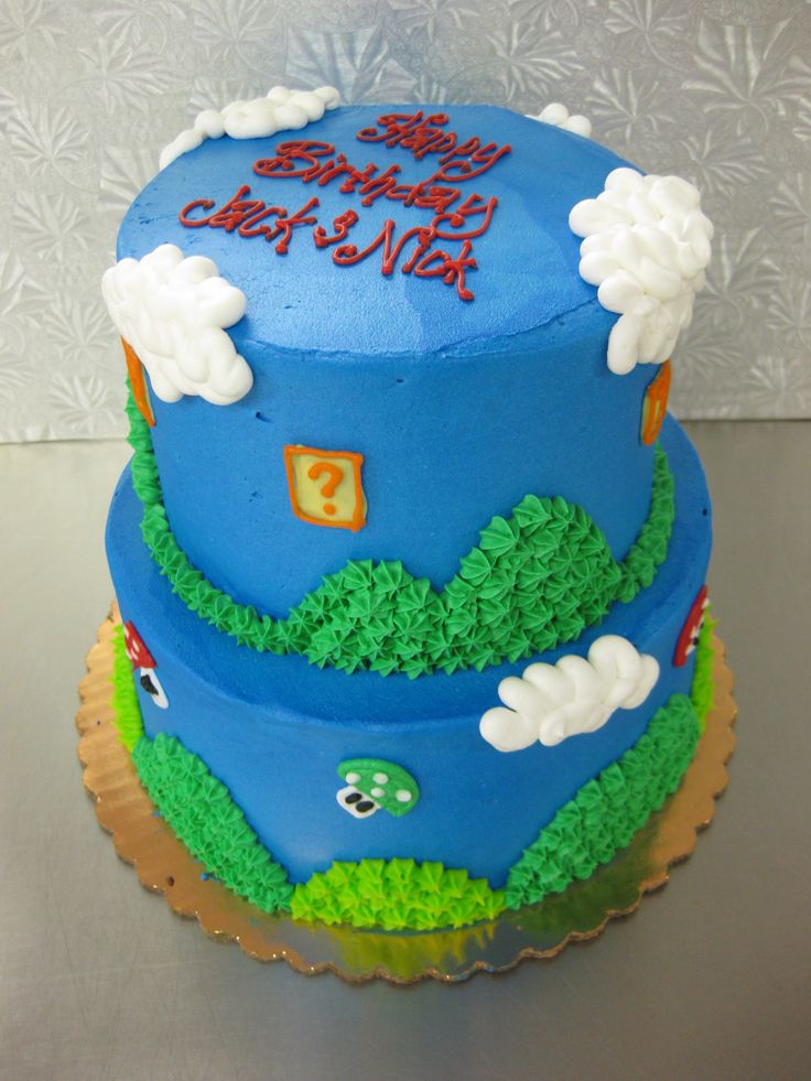 a blue and green birthday cake with white clouds on it's top is sitting on a table