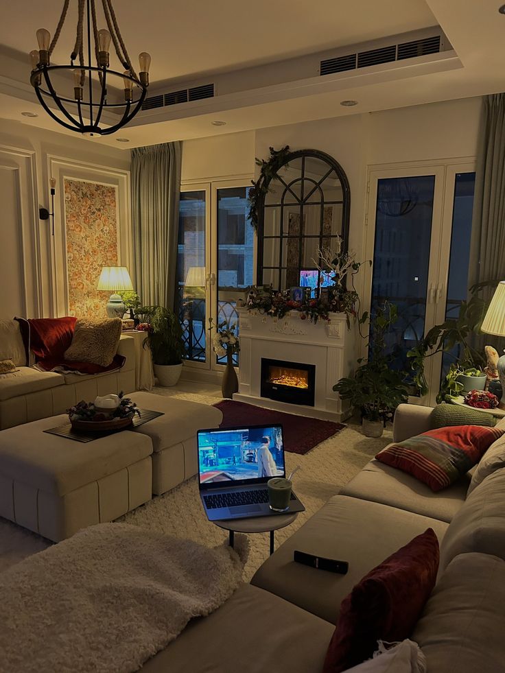 a living room filled with furniture and a laptop computer on top of a coffee table