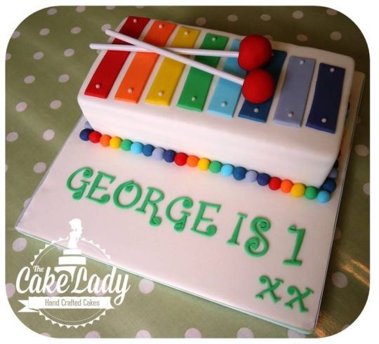 a cake decorated with a musical instrument and the words george is 1 x