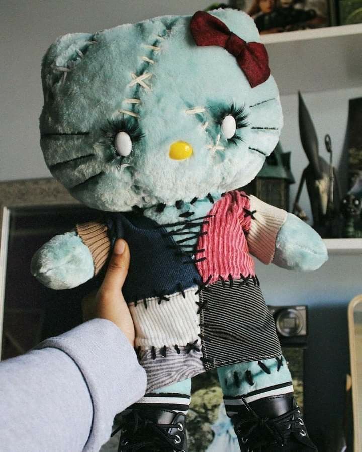 a hello kitty doll being held by someone