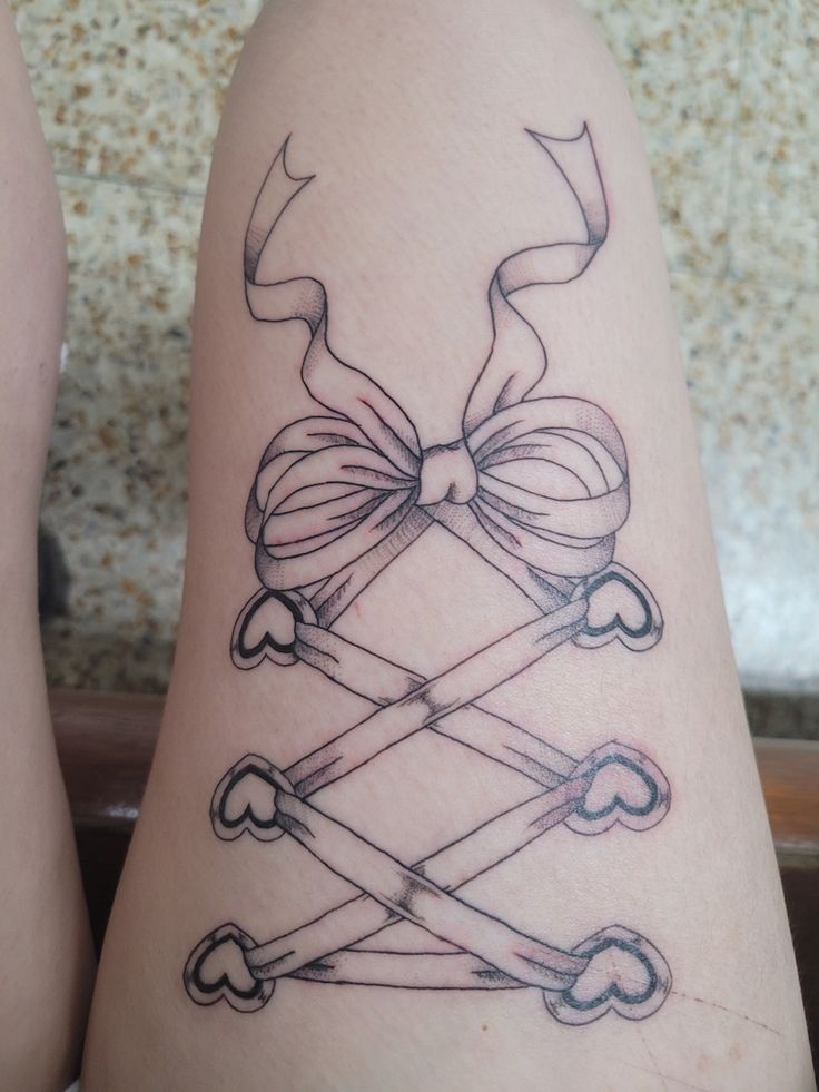 a tattoo on the leg of a woman with bows and arrows around her legs,