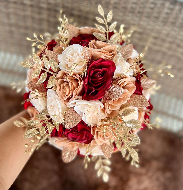 a bridal bouquet is being held by someone's hand