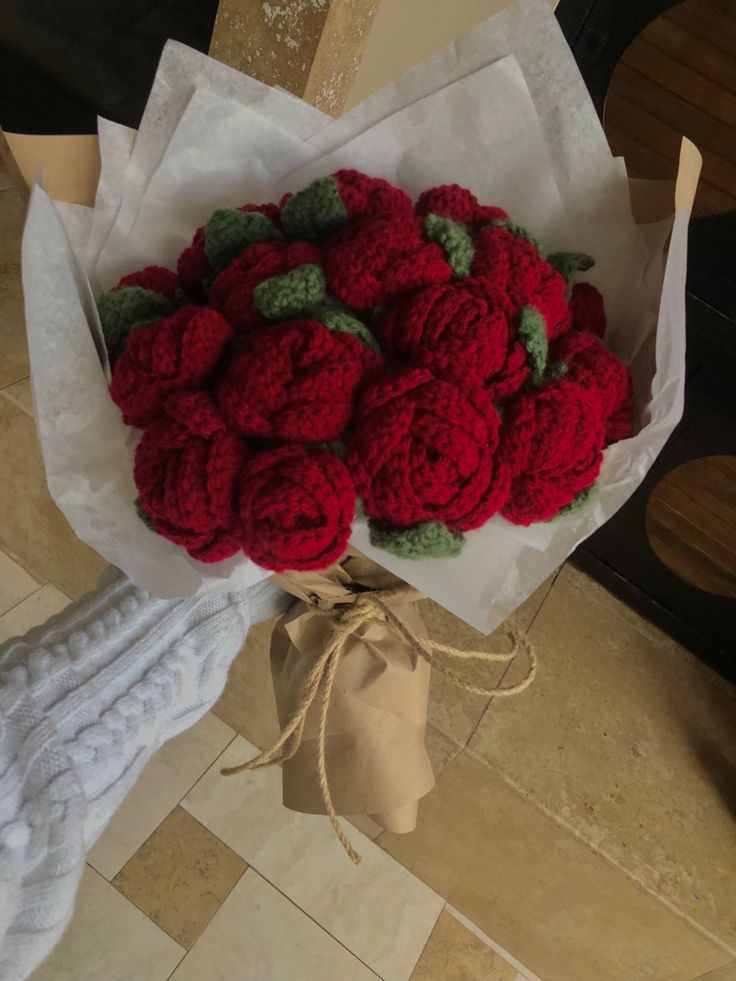 a bouquet of red crocheted flowers sitting on top of a table