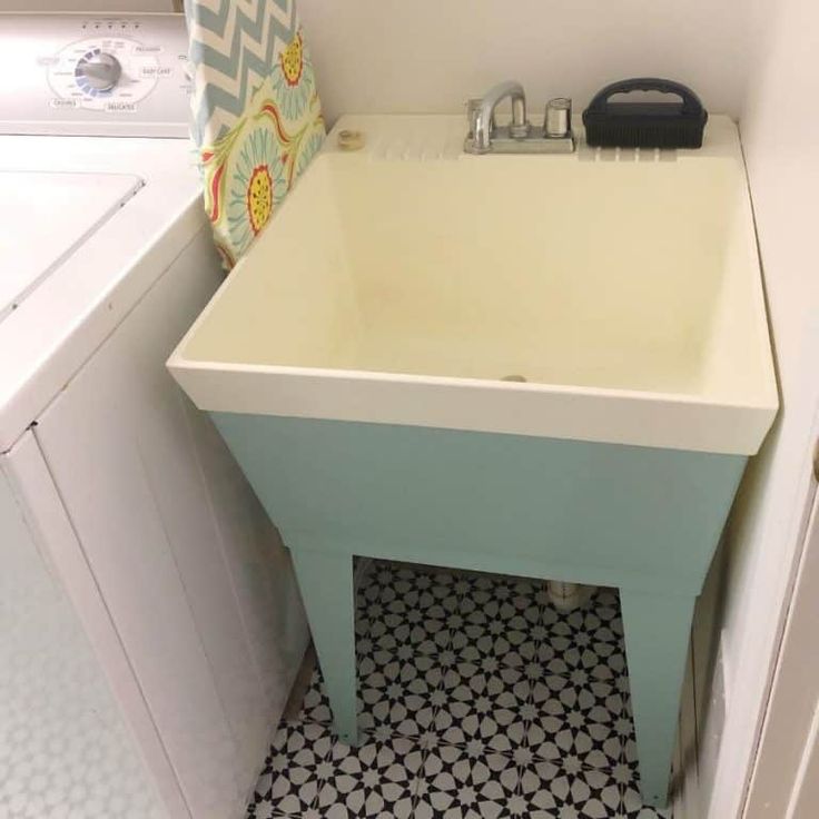 a white sink sitting next to a washer and dryer