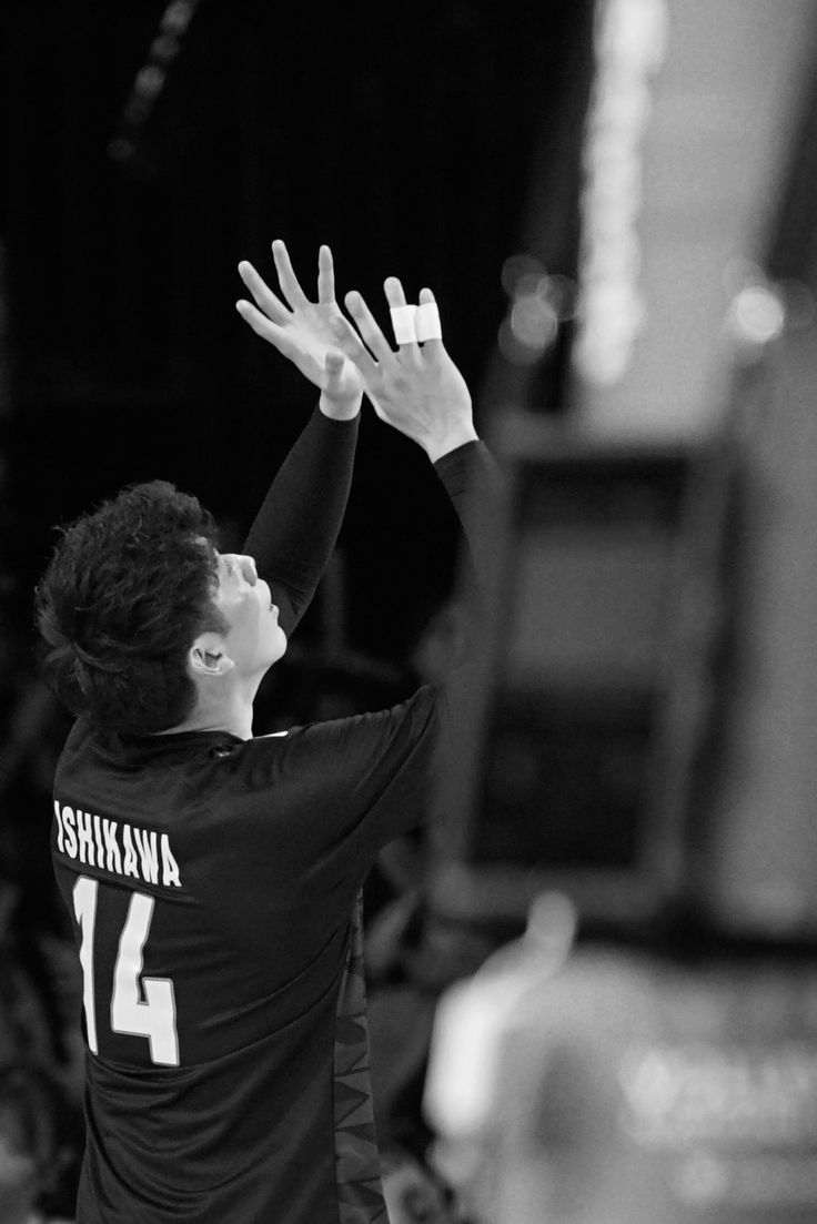 a man reaching up to hit a volleyball