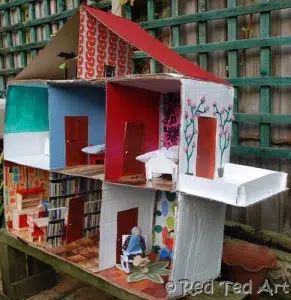 the doll house is made out of cardboard and painted red, white, blue, green and pink