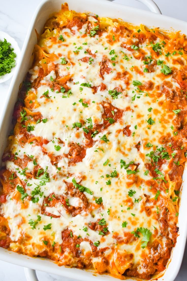 a casserole dish with meat, cheese and parsley