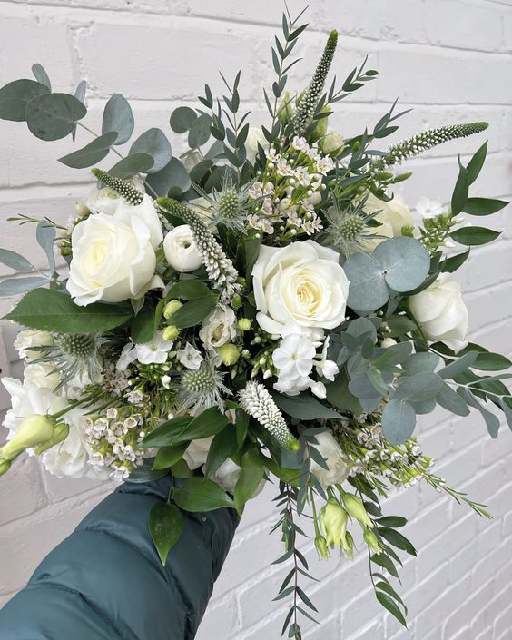 a bouquet of white roses and greenery