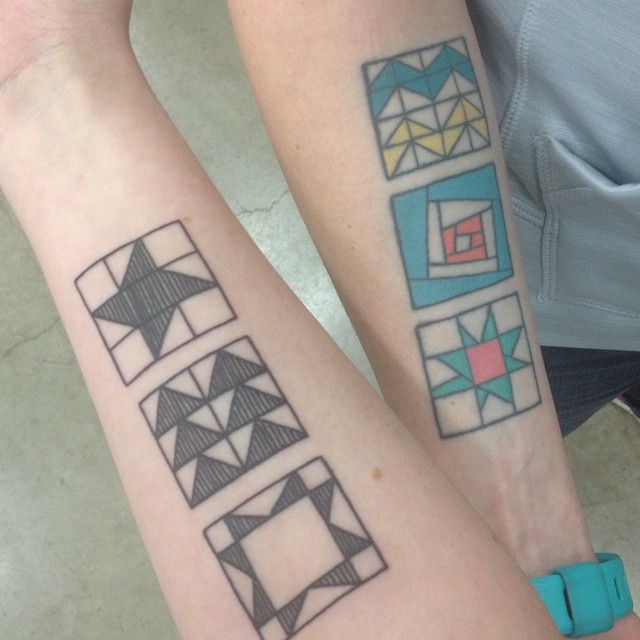 two people with matching tattoos on their arms, both have geometric designs on them and are looking at the camera