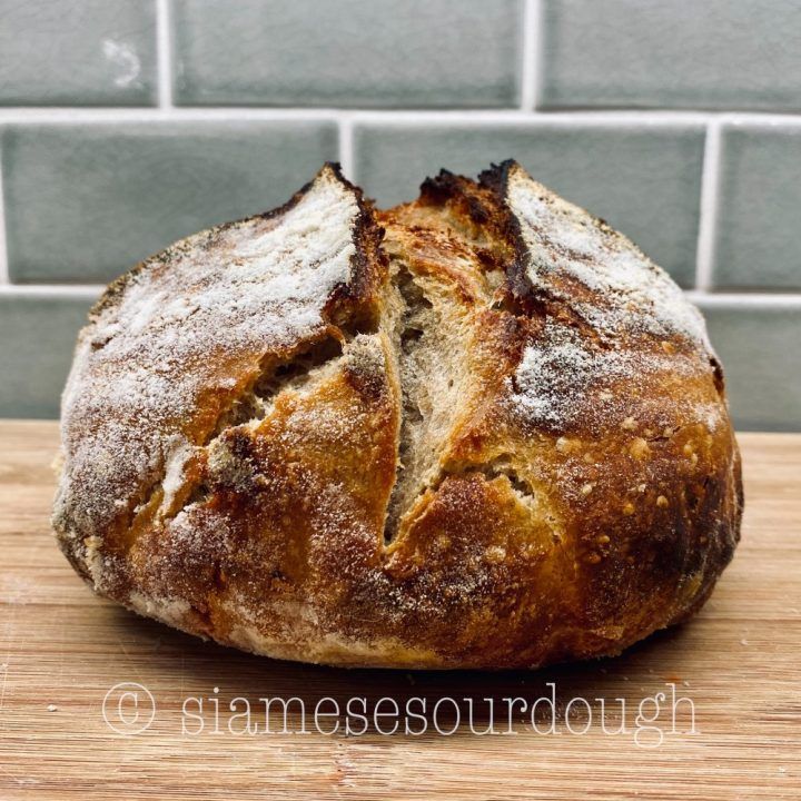 a loaf of bread sitting on top of a wooden cutting board