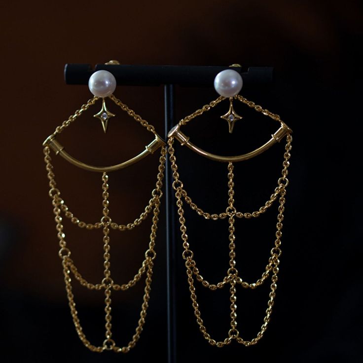 Earrings that look like constellations connected to each other. A design with a golden chain hanging down. Glossy stars and pearls emit a lustrous light. It has an elegant atmosphere as it sways every time you walk. A retro item with an exotic scent. 
 
 
 ＜Item＞ 
 
 Earrings 
 
 
 ＜Size＞ 
 
 Height: 7.7cm 
 Width: 3.5cm 
 
 
 ＜Material＞ 
 
 Alloy 
 
 
 ＜Others＞ 
 
 Please refrain from ordering if you have metal allergies or the plating does not suit your skin. Party Pearl Chain Dangle Earrings, Pearl Chain Dangle Chandelier Earrings For Party, Party Pearl Chain Dangle Chandelier Earrings, Pearl Charm Dangle Chandelier Earrings For Party, Gold Dangle Pearl Earrings For Party, Brass Earrings With Adjustable Chain For Party, Party Brass Earrings With Adjustable Chain, Party Earrings With Adjustable Chain In Brass, Gold Plated Pearl Drop Chandelier Earrings For Party