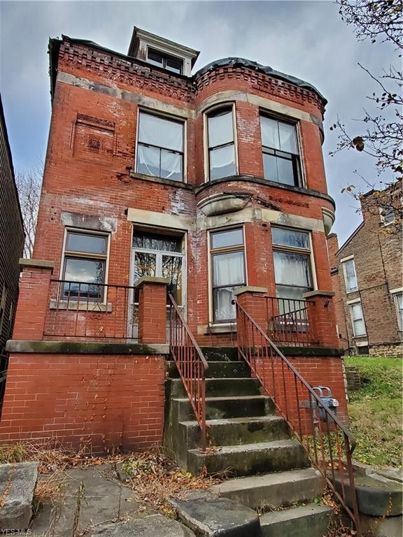 an old red brick building with stairs leading up to the second floor and another one on the other side