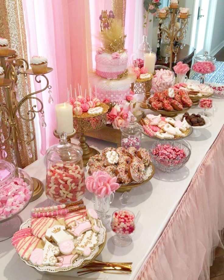 a table topped with lots of pink and gold desserts