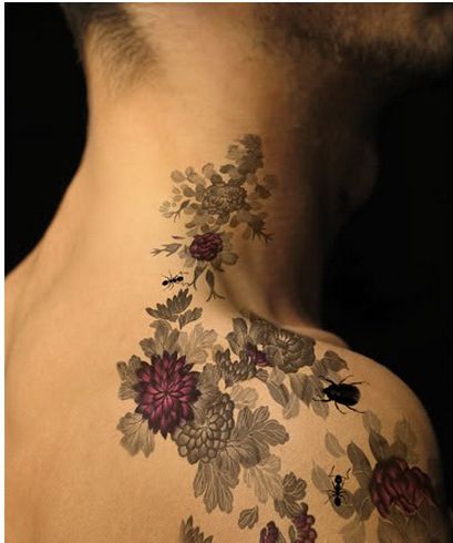 the back of a man's neck with flowers on it