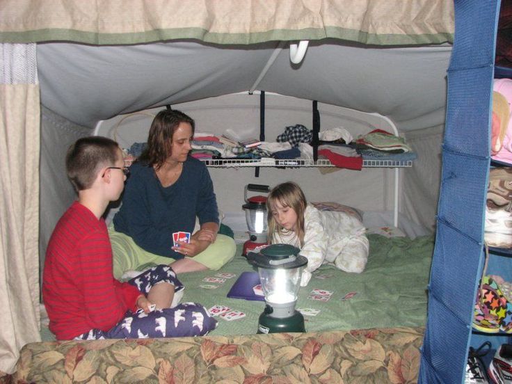 a woman and two children sitting in a tent