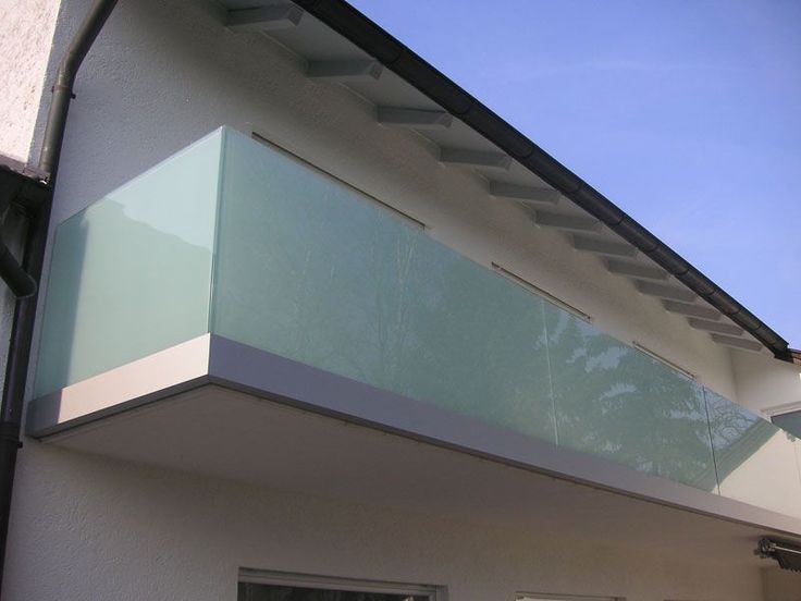 an outside view of a white house with glass balconies