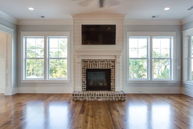 an empty living room with wood floors and a fireplace