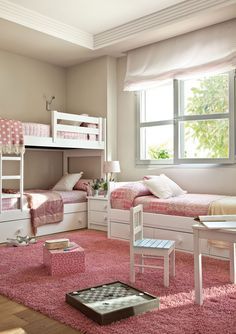 a bedroom with bunk beds and pink rugs on the floor in front of a window