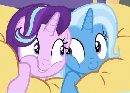 two little ponys laying on top of each other in the same bed with their eyes closed