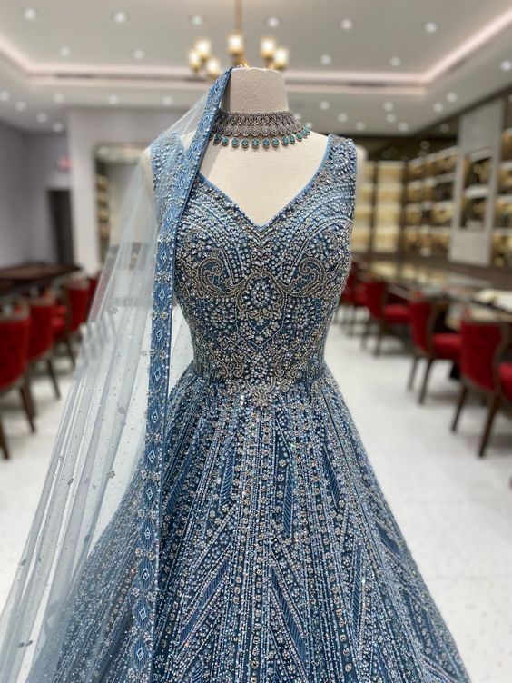 Get ready to say "I do" in style with the Blue Bridal Gown NG-009. This stunning gown features intricate silver work that adds a touch of elegance to the beautiful blue fabric. You'll feel like a fairy-tale princess on your special day. Fabric: Net with Satin Silk! WASH CARE INSTRUCTIONS - Please Dry clean only when it is applicable! Ready to Ship! Blue Embellished Ball Gown With Fitted Bodice, Blue Ball Gown For Wedding, Silver Hand Embellished Anarkali Dress, Blue Floor-length Ball Gown For Wedding, Embellished Blue Dresses For Reception, Blue Embellished Dress For Reception, Embellished Blue Dress For Reception, Blue Embellished Evening Dress For Reception, Embellished Blue Evening Dress For Reception