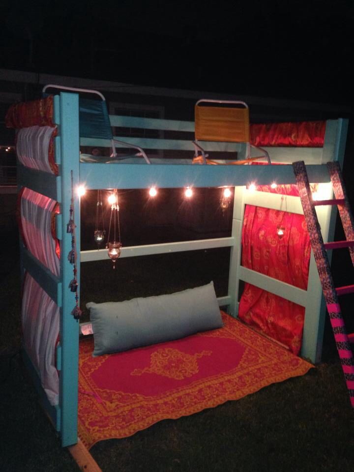 the bunk bed is decorated with lights and blankets on it's sides, as well as pillows