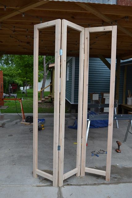 an open wooden door sitting on top of a cement floor next to a building under construction