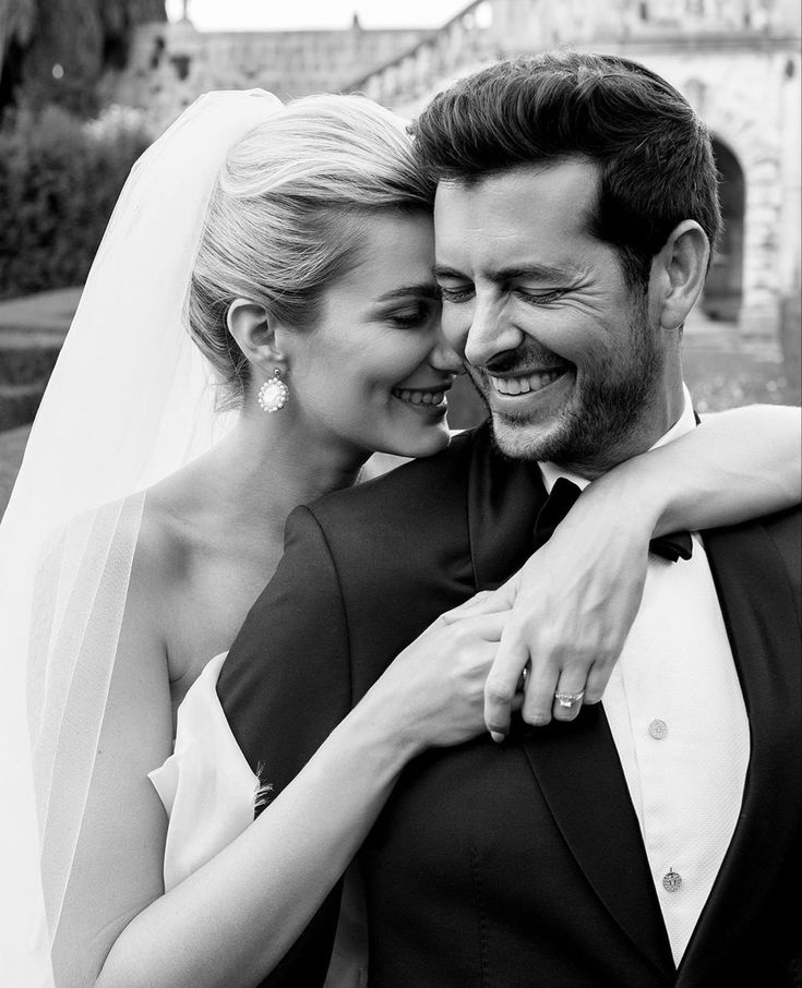 a bride and groom embracing each other in black and white