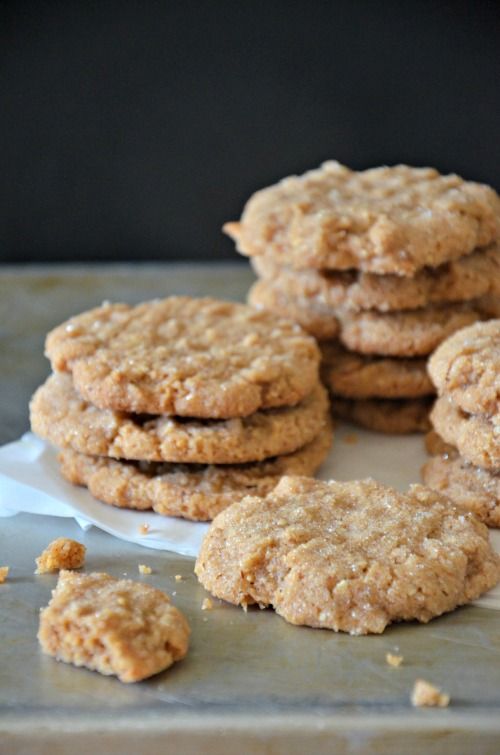 cookies are stacked on top of each other on a baking sheet with parchment paper next to them