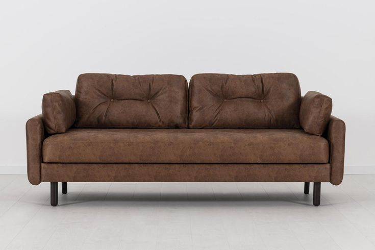 a brown couch sitting on top of a white floor