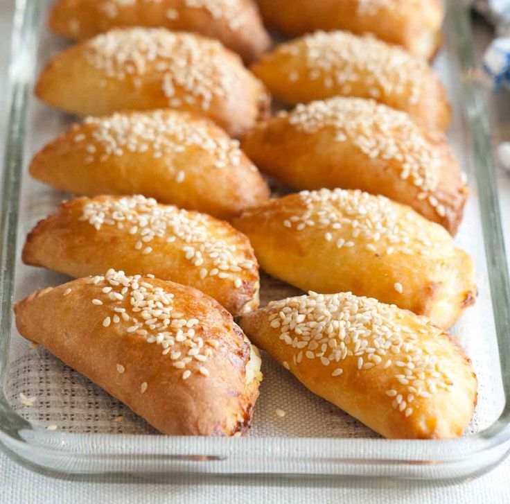 bread rolls with sesame seeds in a glass baking dish