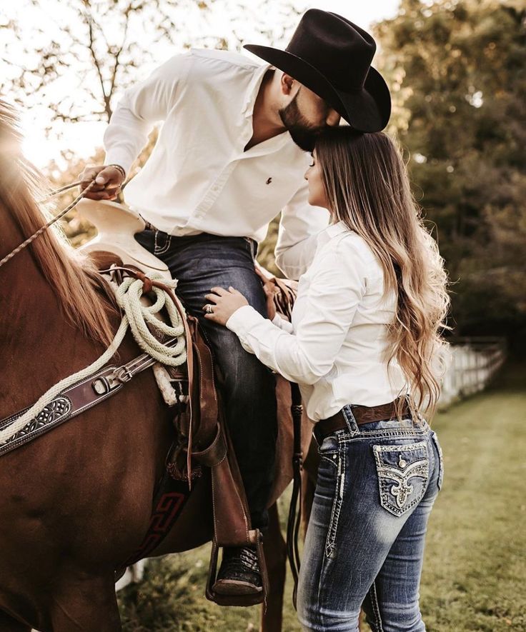 a man and woman riding on the back of a brown horse next to each other