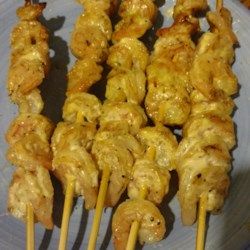 several skewers of food sitting on a plate