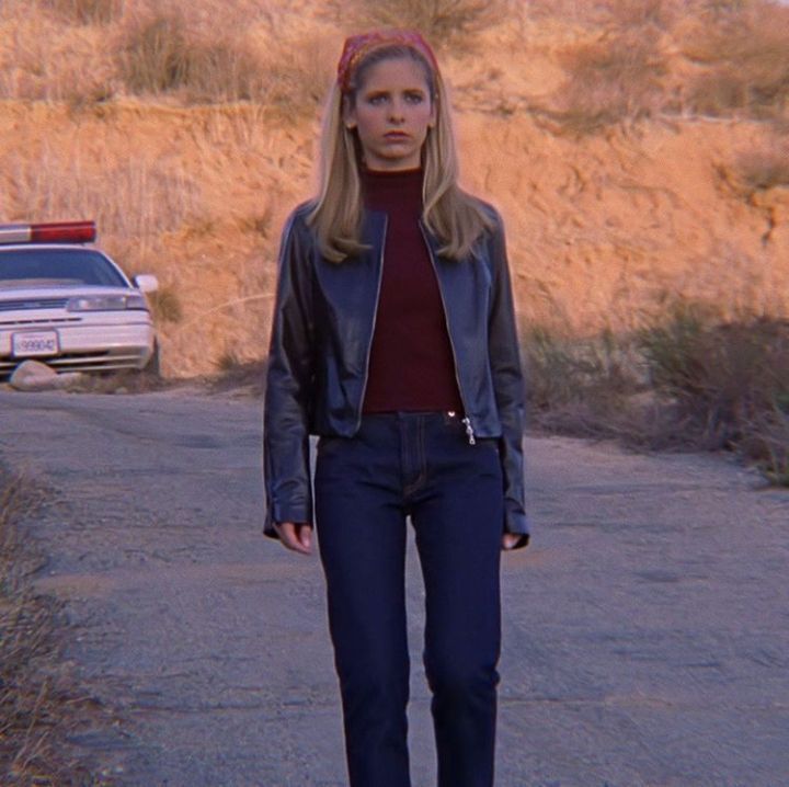 a woman standing on the side of a road