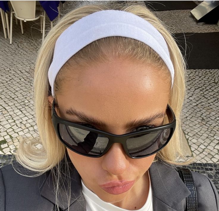 a woman wearing sunglasses and a white headband