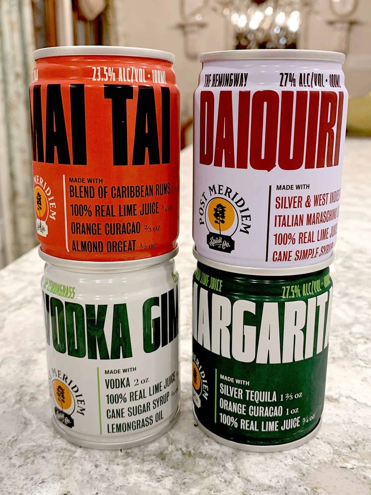 three cans of various flavored beverages sitting on a counter