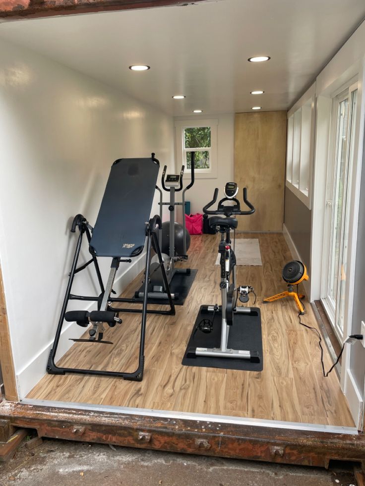 there are many exercise equipment in the room that is being used as a home gym