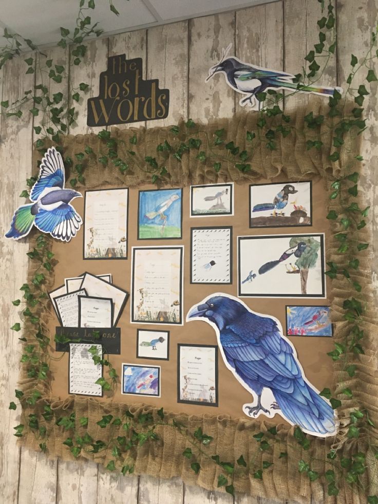 a blue bird sitting on top of a wooden wall next to pictures and plants in front of it